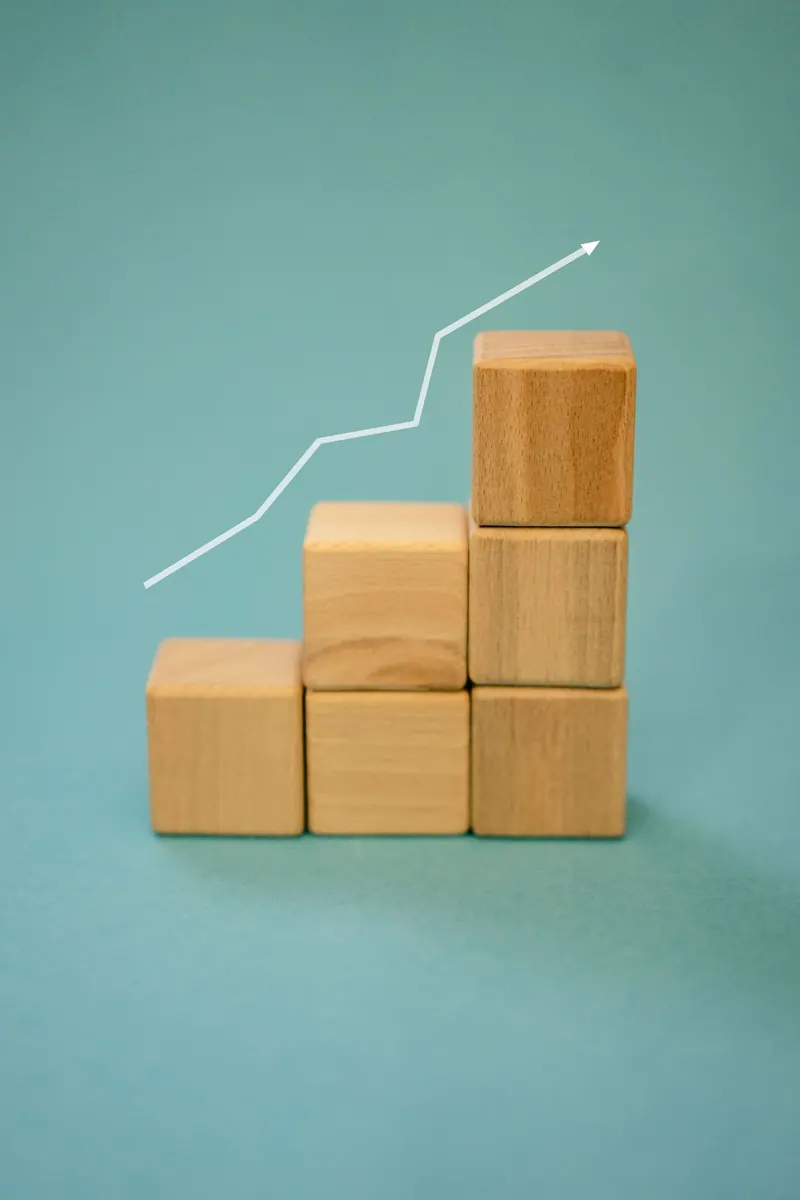 Wooden blocks forming a staircase with an upward arrow