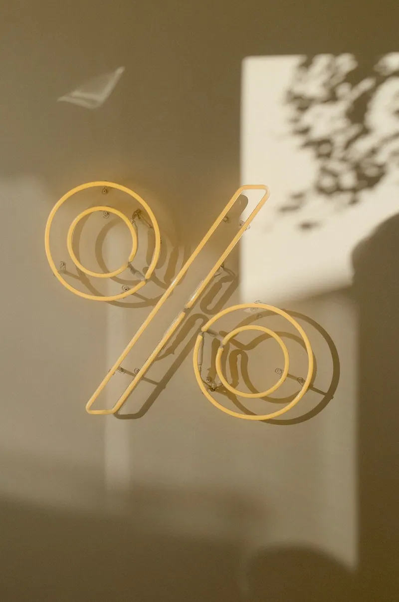 A neon percentage sign glowing yellow